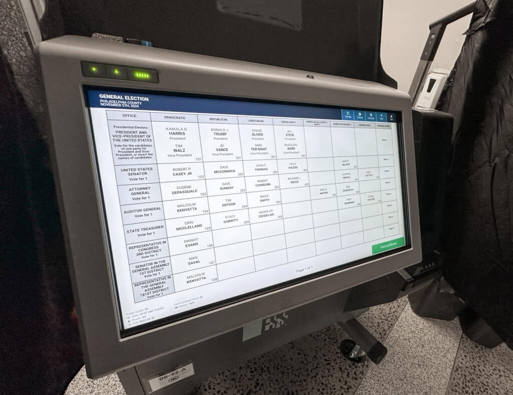 Electronic voting machine displaying a ballot screen with various candidate names and positions.