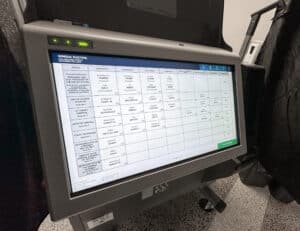 Electronic voting machine displaying a ballot screen with various candidate names and positions.